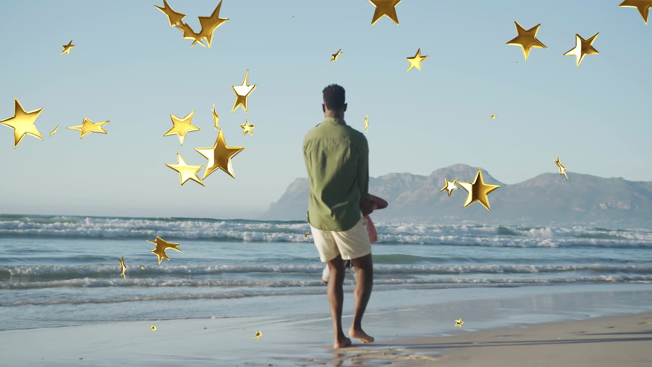 Un garçon s'approche de son père, qui le fait se balancer sur la plage, des étoiles dorées venant enrichir le divertissement.