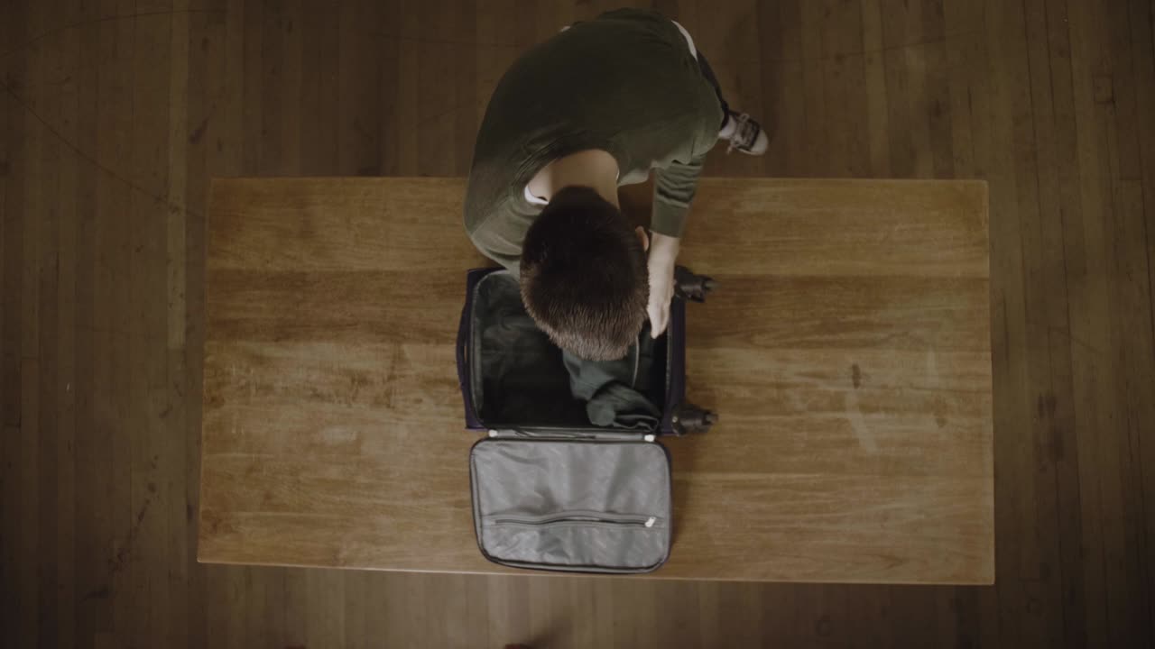 Young Man Packing His Things Fo A Long Trip - Top View Shot
