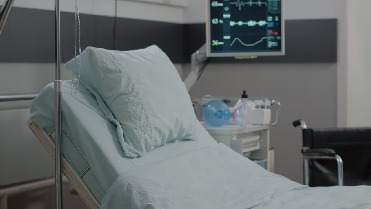 Close up of IV drip bag and empty hospital ward bed