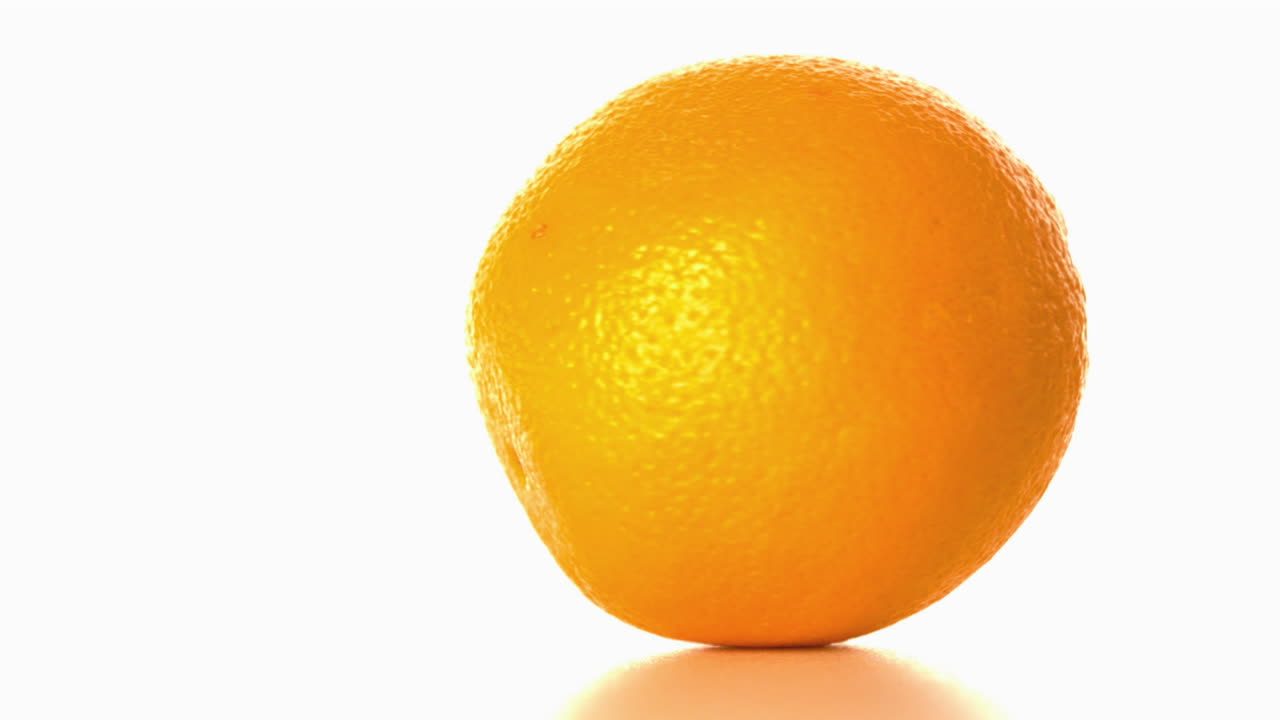 Appelsin snurrer rundt på en hvid overflade
