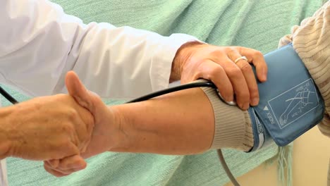 doctor taking the blood pressure of his patient