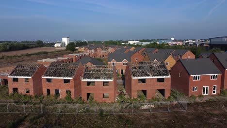 residential housing framework aerial view wide orbit across unfinished rooftop development on urban building site real estate