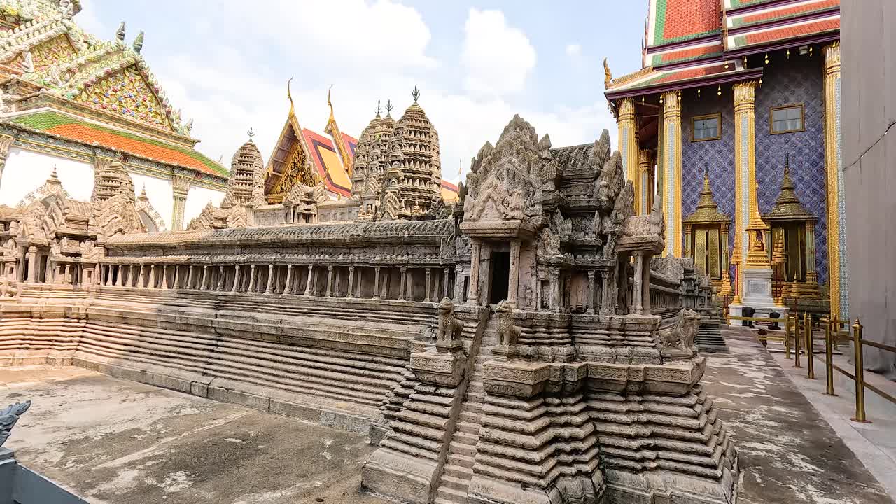 una vista detallada de las estructuras ornamentadas de wat phra kaew en bangkok, que muestran tallas intrincadas y colores vibrantes bajo la luz natural del día