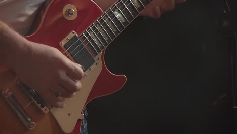 guitarist plays the guitar at a concert as part of a musical group 1