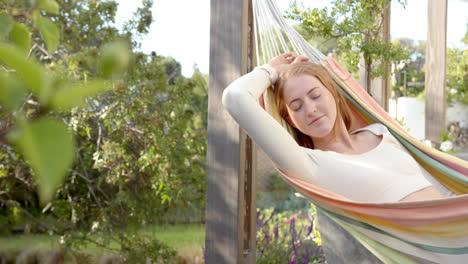 relaxing in hammock, woman enjoying peaceful moment in backyard garden