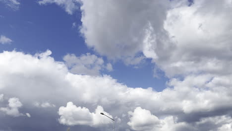 street light post against fluffy clouds at the sky