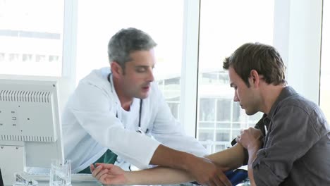 male doctor examining a patients blood pressure