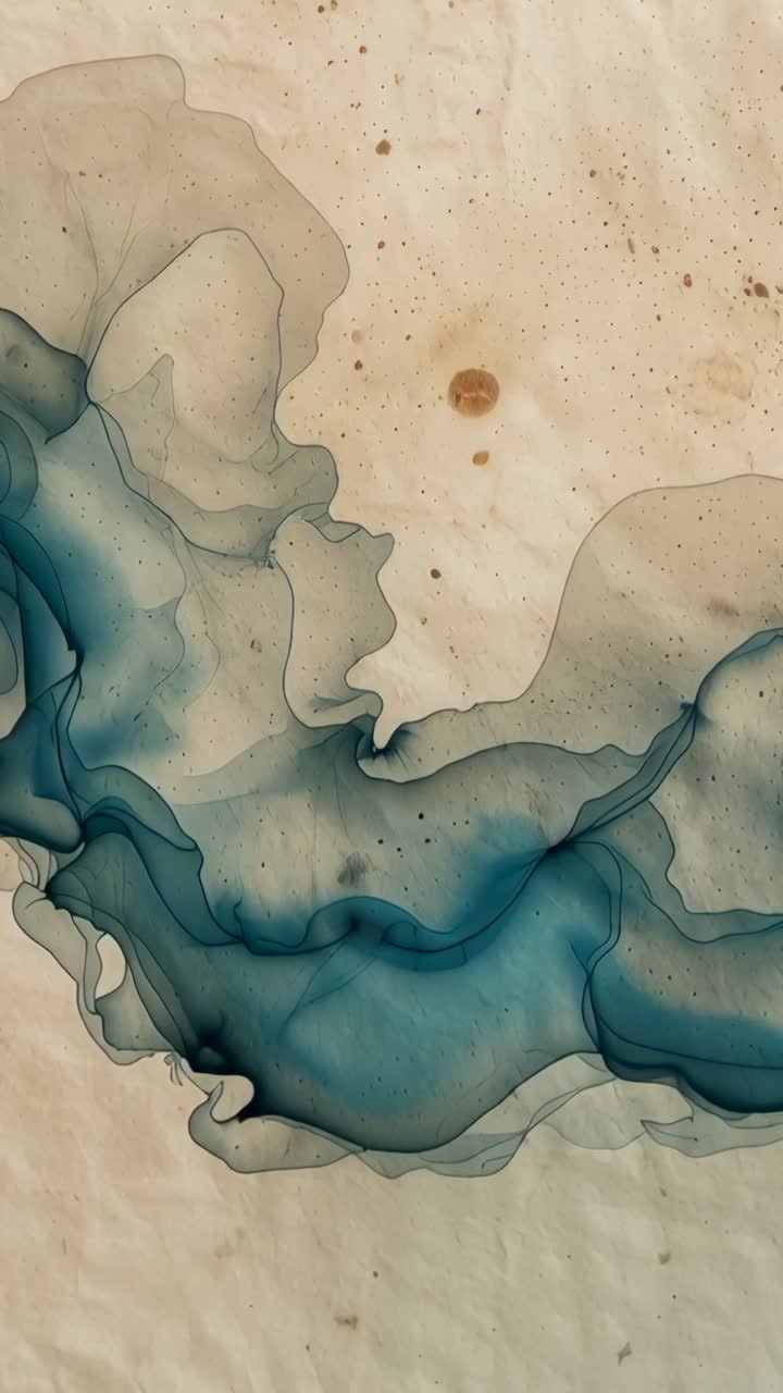 Video verticale: Velatura color verde acqua che si muove, ripresa dalla telecamera su carta color crema, con macchioline marroni.