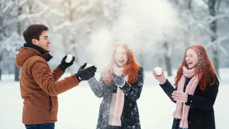 Friends having a joyful snowball fight in a snowy park