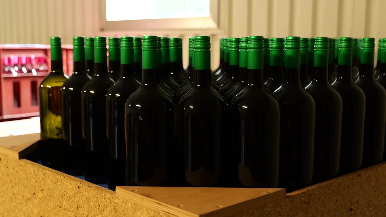 botellas de vino oscuro con tapas verdes en la sala de almacenamiento