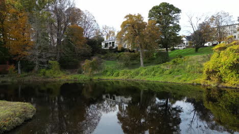 Lush-green-hillside-with-calm-shimmering-water-and-grassy-island-of-college-campus