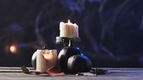 candles and pumpkins set a spooky mood on a wooden surface