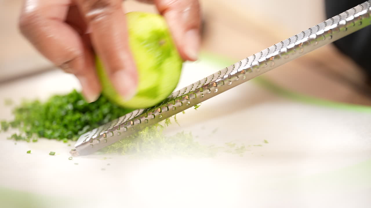 홈메이드 레시피에 향긋한 껍질 입자를 추가하기 위해 라임 제스팅 - 슬로우 모션의 측면 보기