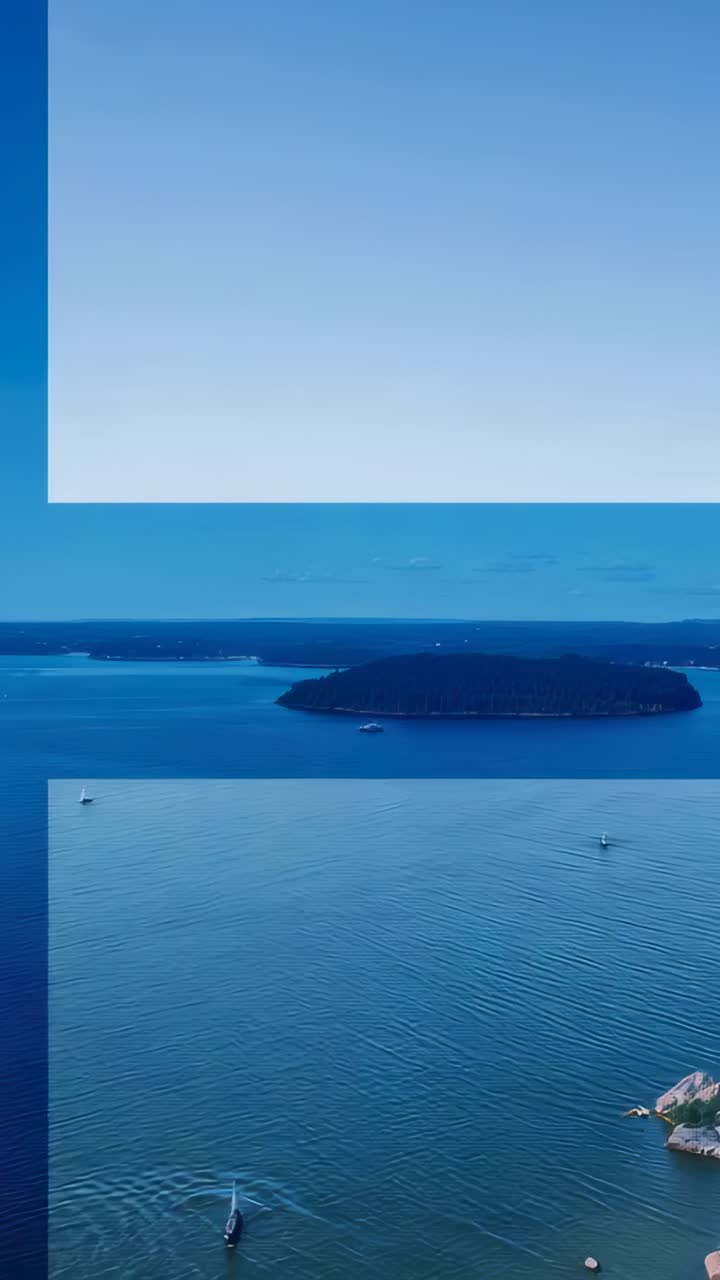 Vertical video: Descending drone capturing wooded island over bay, revealing boats leaving wakes