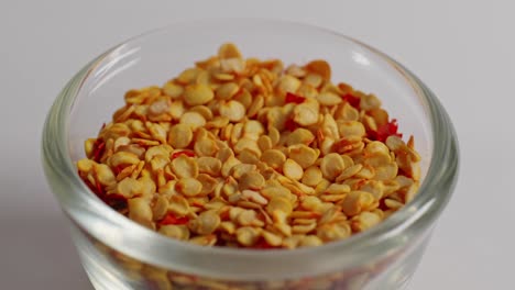 chilli flakes in small glass bowl, closeup, 4k, parallax shot.