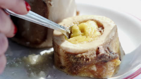 women eating traditional bone marrow at restaurant cu