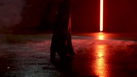 woman standing in boots on wet and foggy street in slow-motion