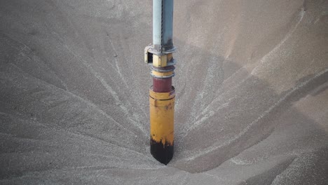 primer plano del vacío de una bomba de grano sumergido en trigo mientras succiona el trigo para descargarlo