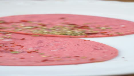 close-up of slices of salami on a white plate