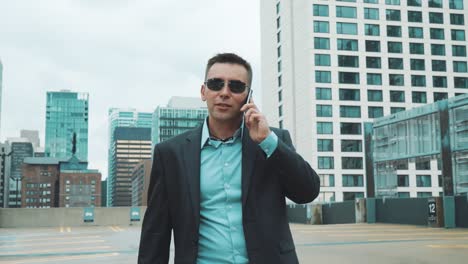 young man in suit talking on phone in city. handsome businessman in suit