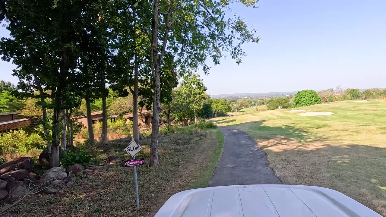 골프 카트는 울창하고 경치 좋은 풍경을 여행합니다.