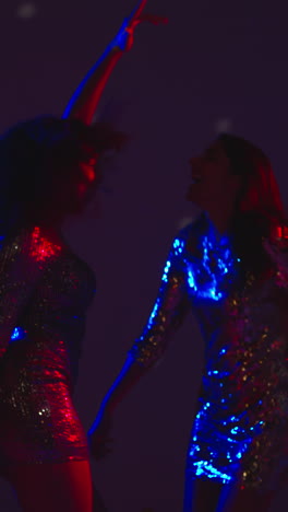 Vertical-Video-Of-Two-Women-In-Nightclub-Bar-Or-Disco-Dancing-With-Sparkling-Lights-In-Background