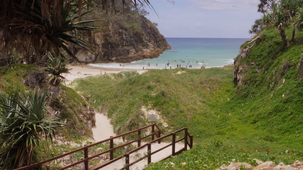 paseo marítimo hacia la playa principal con gente en vacaciones de verano - north stradbroke island, queensland, australia