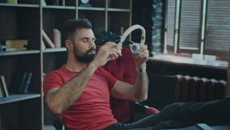 joven hombre de negocios poniendo los pies en la mesa y relajándose con auriculares