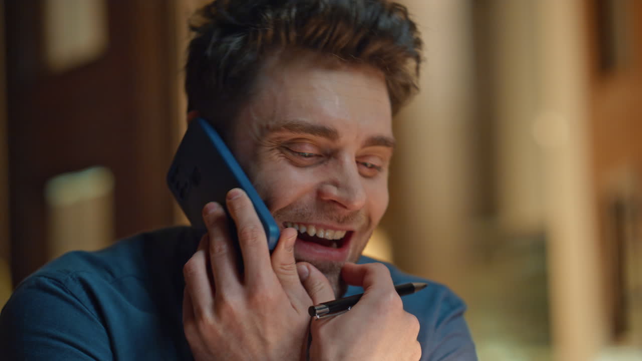 Joyful guy talking smartphone having fun at late apartment closeup. Man laughing