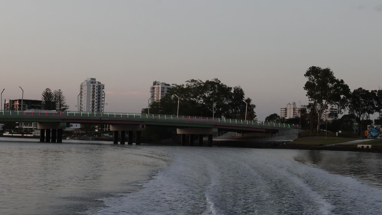 스피드 보트 는 저녁 에 도시 다리  에서 눈길 을 일으킨다