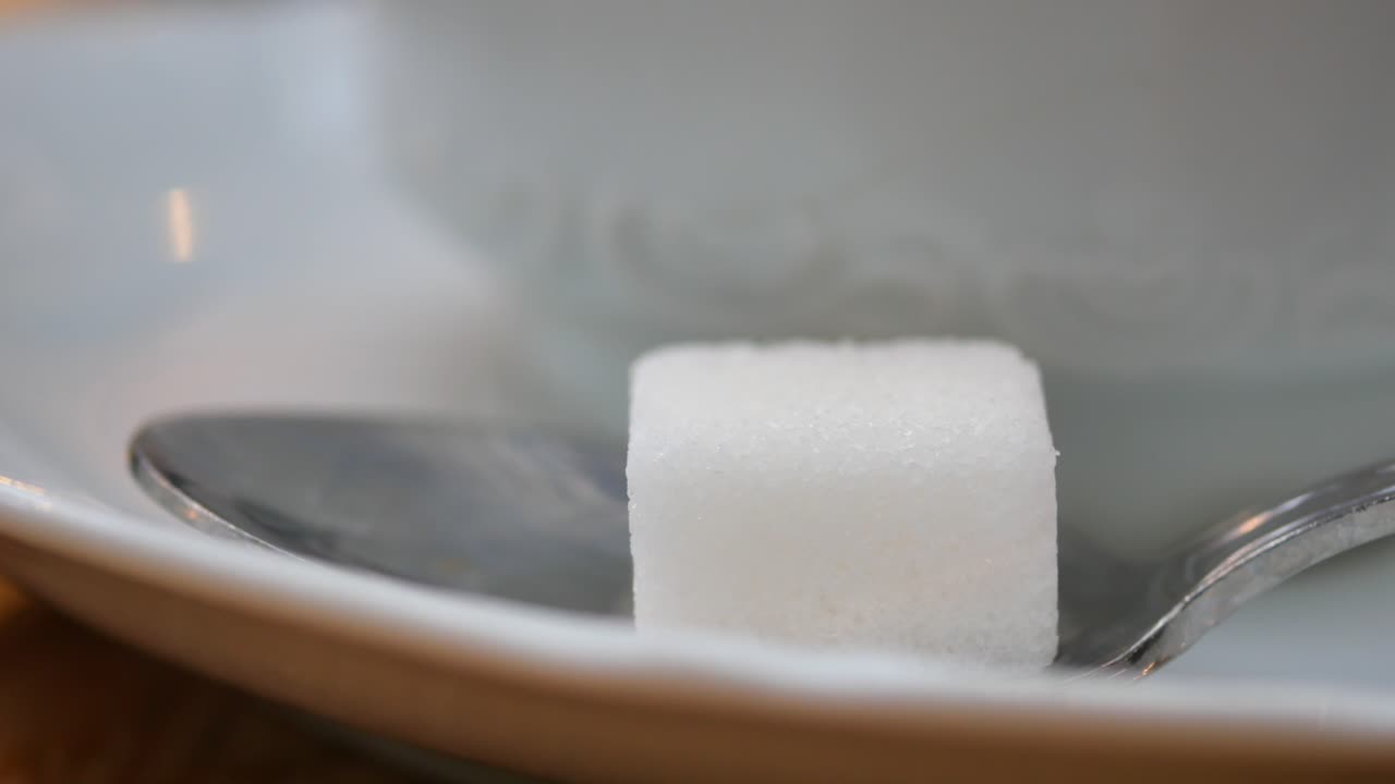 un cubo de azúcar en una cuchara