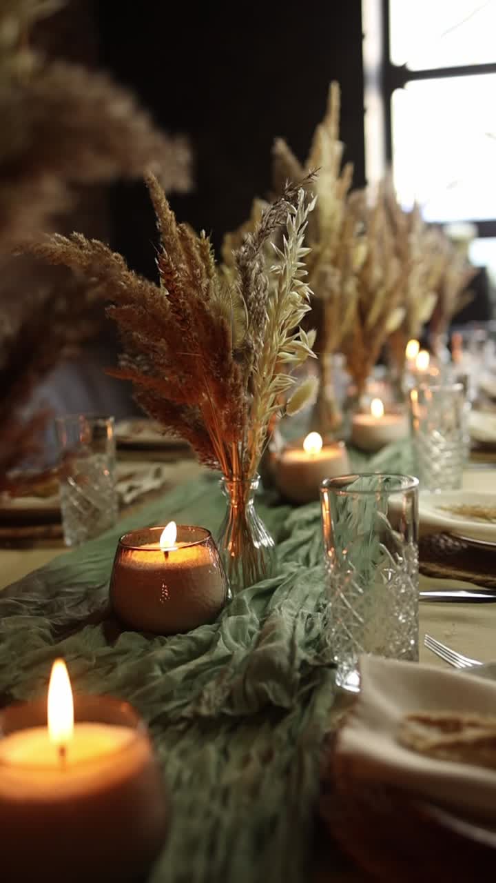 Elegant Table Setting with Flickering Candles and Dried Floral Decor