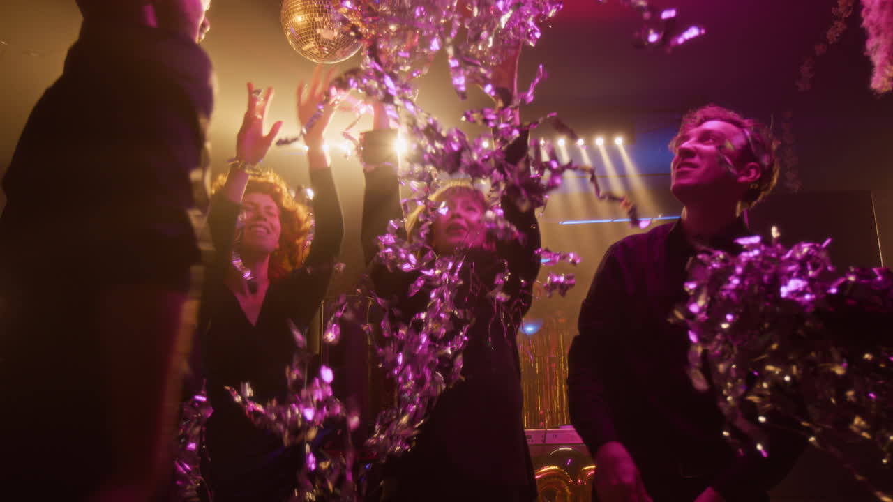 People celebrating at a party with confetti and disco ball
