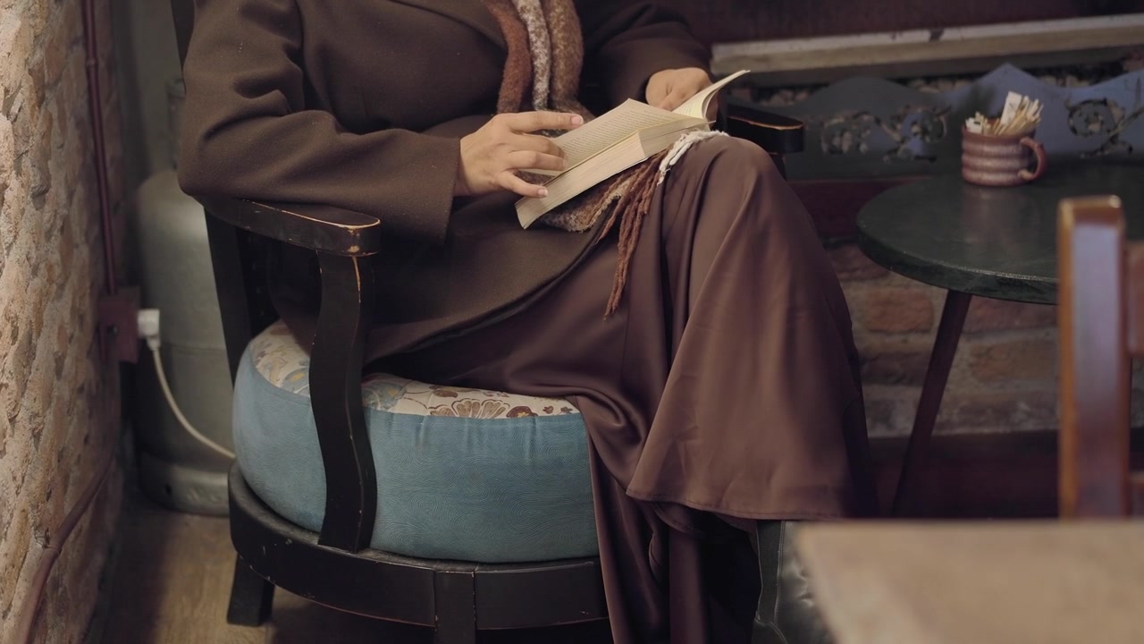 Donna che legge un libro seduta in un caffè