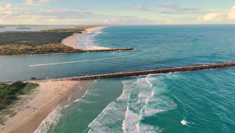 drone captures waves and coastline at sunset