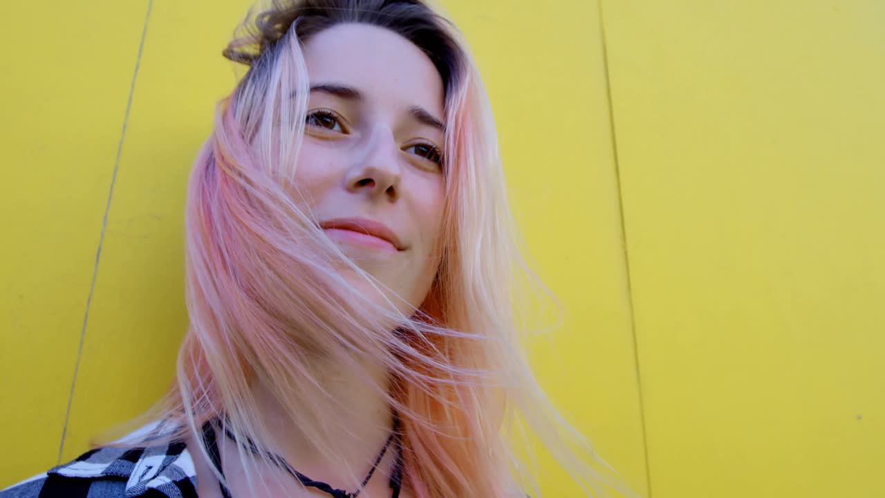 노란색 벽 4k에 대항하는 젊은 여성