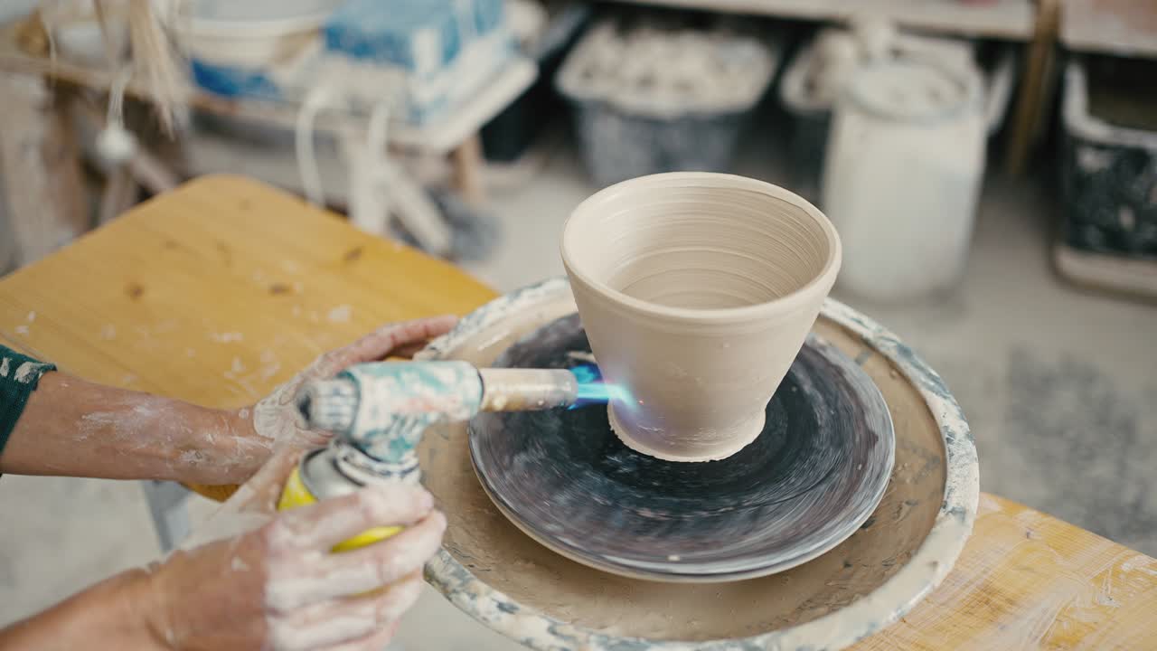 cerámica femenina disparando una olla de cerámica en una rueda de cerámica, disparo de seguimiento, primer plano, cámara lenta