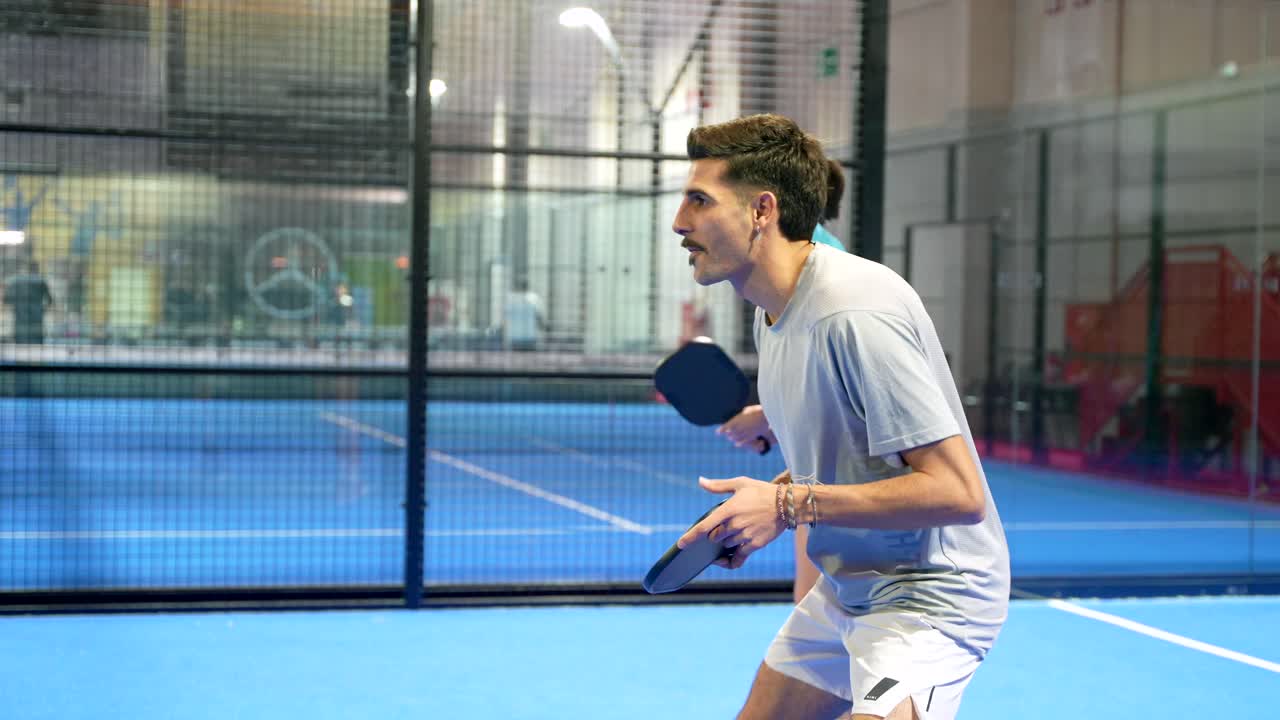 Mann und Frau spielen Padel-Tennis auf einem Hallenplatz