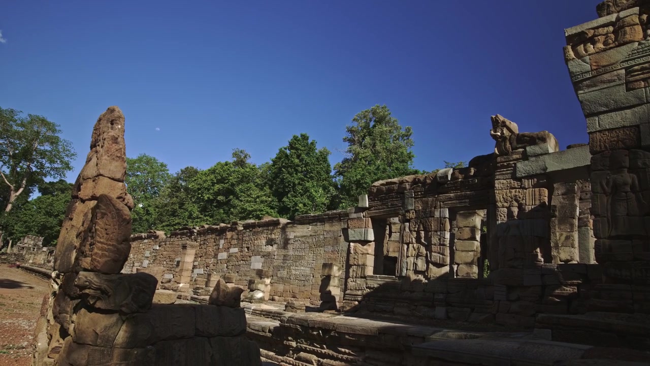 Antiche statue di leoni in arenaria angkoriana si affacciano sul lago baray ricoperto d'erba all'inizio della stagione delle piogge. Time lapse con movimento dinamico e controllo del movimento