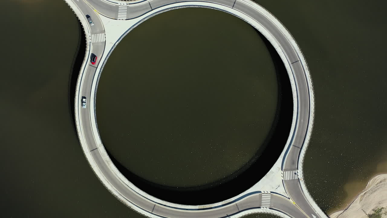 Cars Crossing Circular Bridge Over Laguna Garzon Uruguay, Bird's eye Drone Rotate
