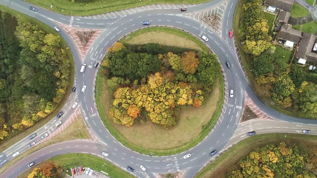 Aerial rising high angle view above roundabout traffic junction transport