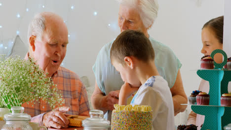 Side-view-of-Caucasian-grandchildren-giving-gifts-to-grandfather-in-a-comfortable-home-4k
