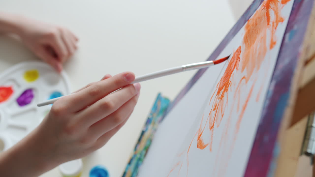 Child Painting with Orange