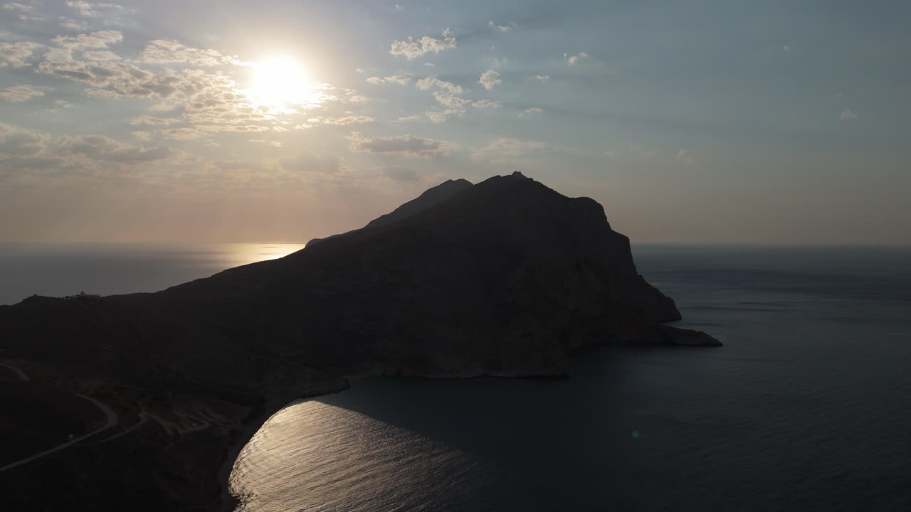 Pôr do sol sobre uma costa montanhosa