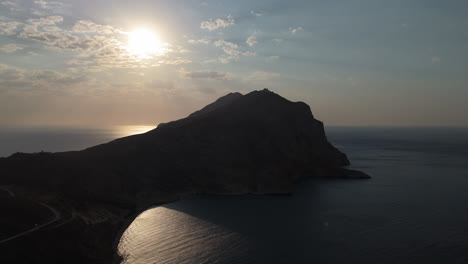 sunset over a mountainous coastline