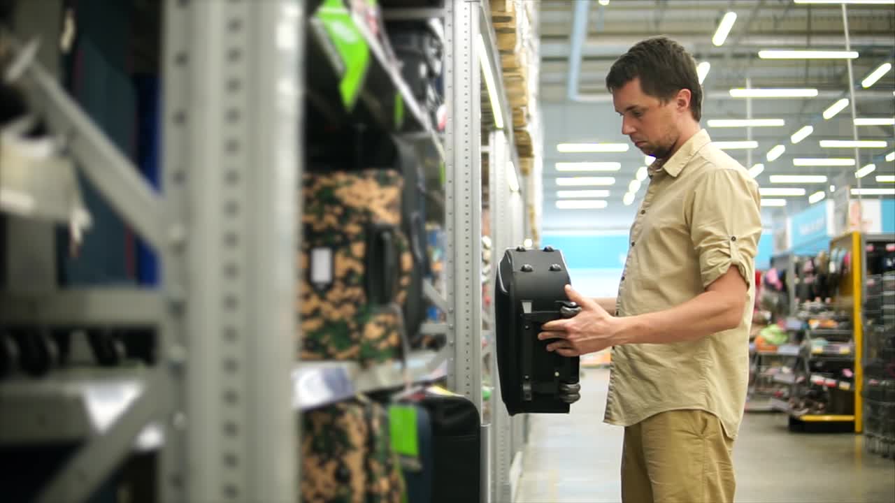 hombre comprando equipaje en una tienda