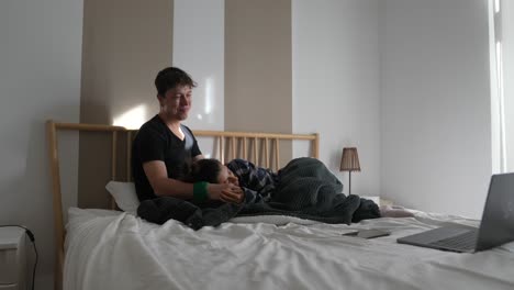 couple relaxing in bed watching a movie