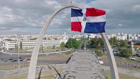 flag of the dominican republic flying at flag square with santo domingo city in the background in dominican republic