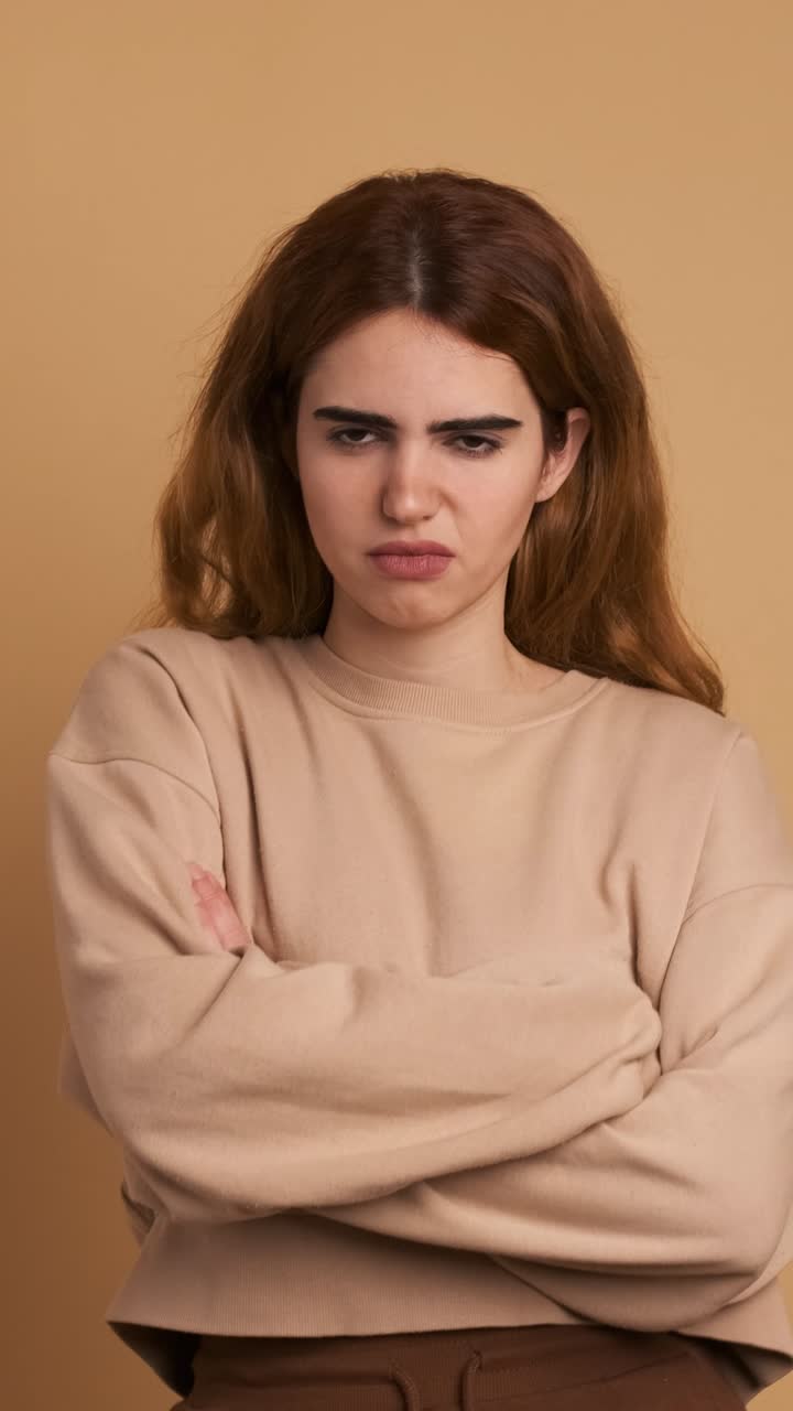 Angry young woman crossing arms and looking at camera. Vertical Footage