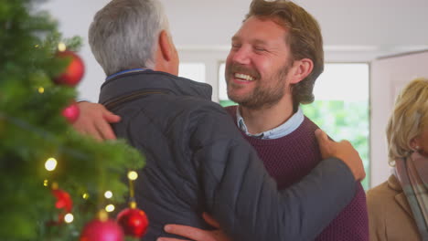 Una-Pareja-Saluda-A-Los-Padres-Mayores-Cuando-Llegan-Con-Regalos-Para-Celebrar-La-Navidad.